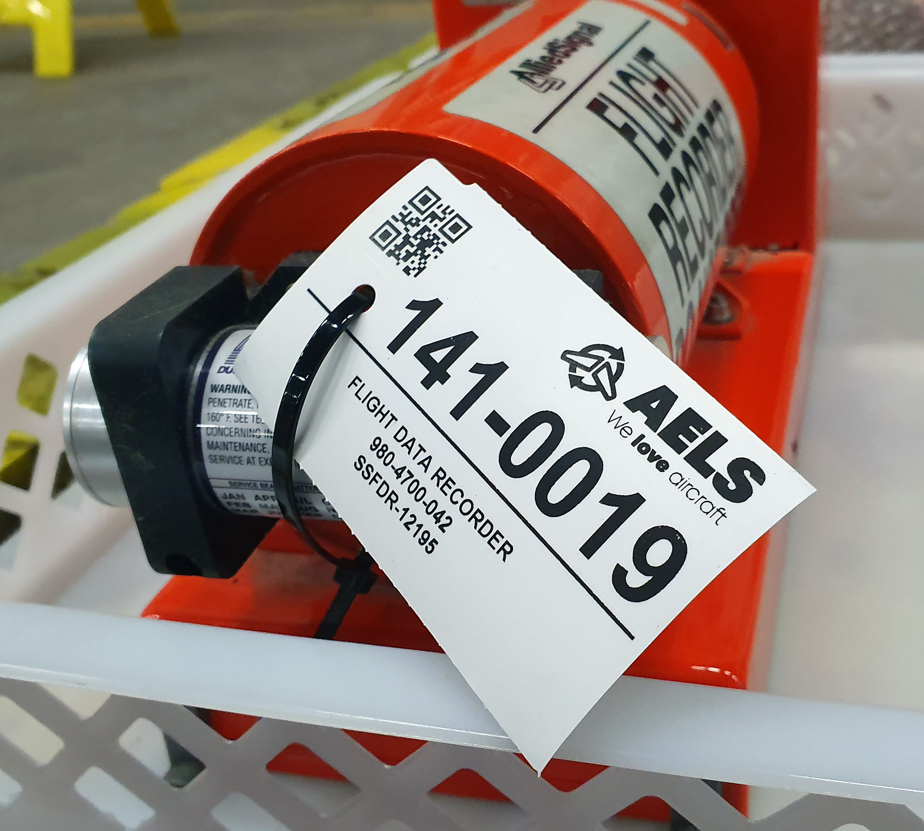 Industriële tag met identificatiegegevens zoals een QR-code bevestigd aan een zwarte doos voor gebruik in een vliegtuig