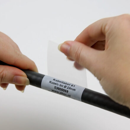 Close-up van twee handen die een kabellabel om een kabel wikkelen